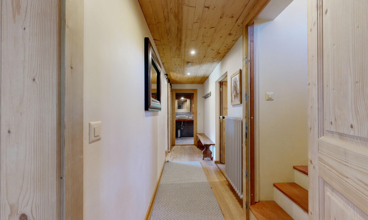 couloir avec cloison sèche, drywall, sol en finition bois, wood finish floor, et plafond en bois