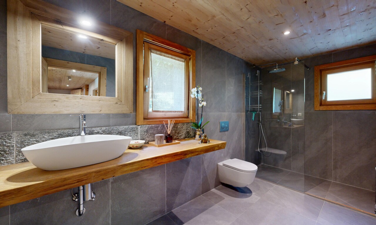salle de bains avec mur en carrelage, tile wall, miroir, lavabo (ou coiffeuse selon le contexte), et évier
