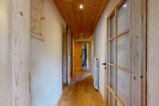 couloir avec plafond en bois, wood ceiling, éclairage encastré, recessed lighting, et sol en finition bois