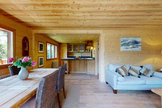 salon / salle à manger avec mur en bois, wood wall, light floor, inside property, et sol en finition bois