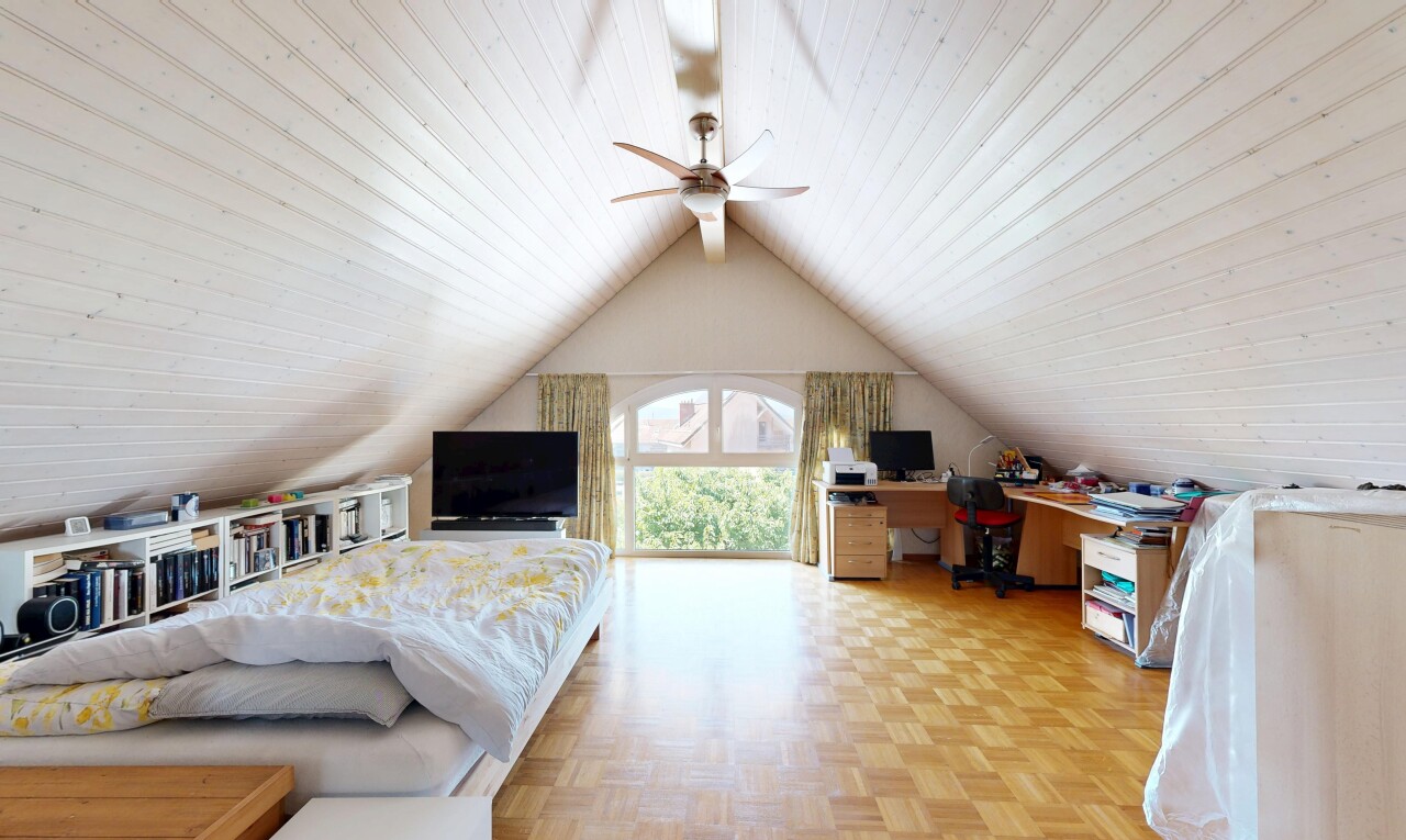 chambre avec télévision, cathedral ceiling, plafond cathédrale, espace bureau, et parquet floor