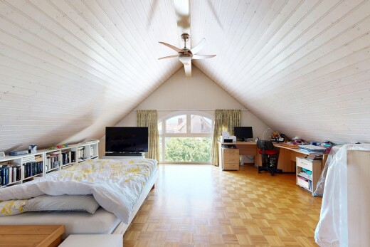 chambre avec télévision, cathedral ceiling, plafond cathédrale, espace bureau, et parquet floor