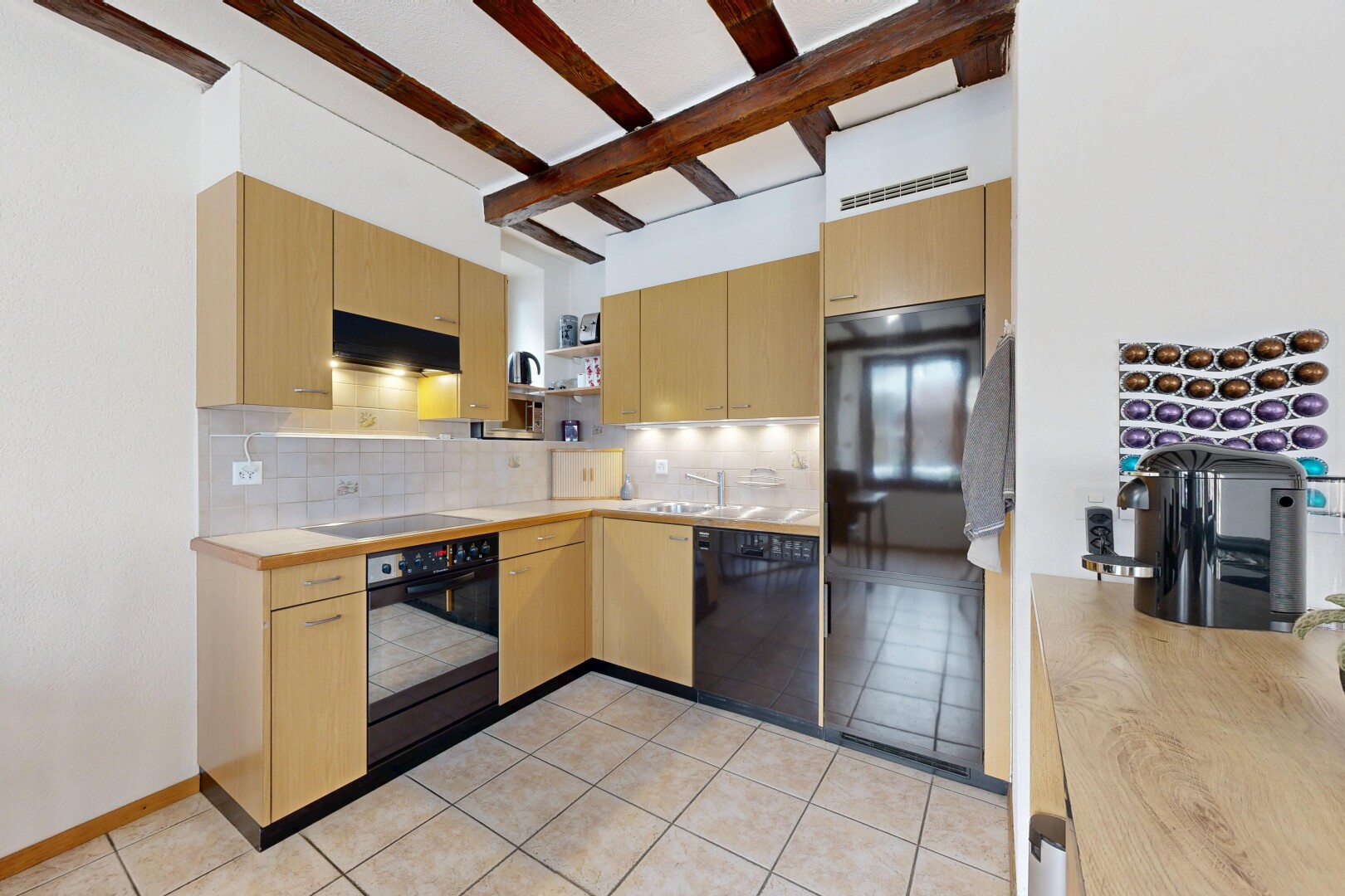 cuisine avec armoires marron clair, étagères ouvertes, four, lave-vaisselle, et backsplash
