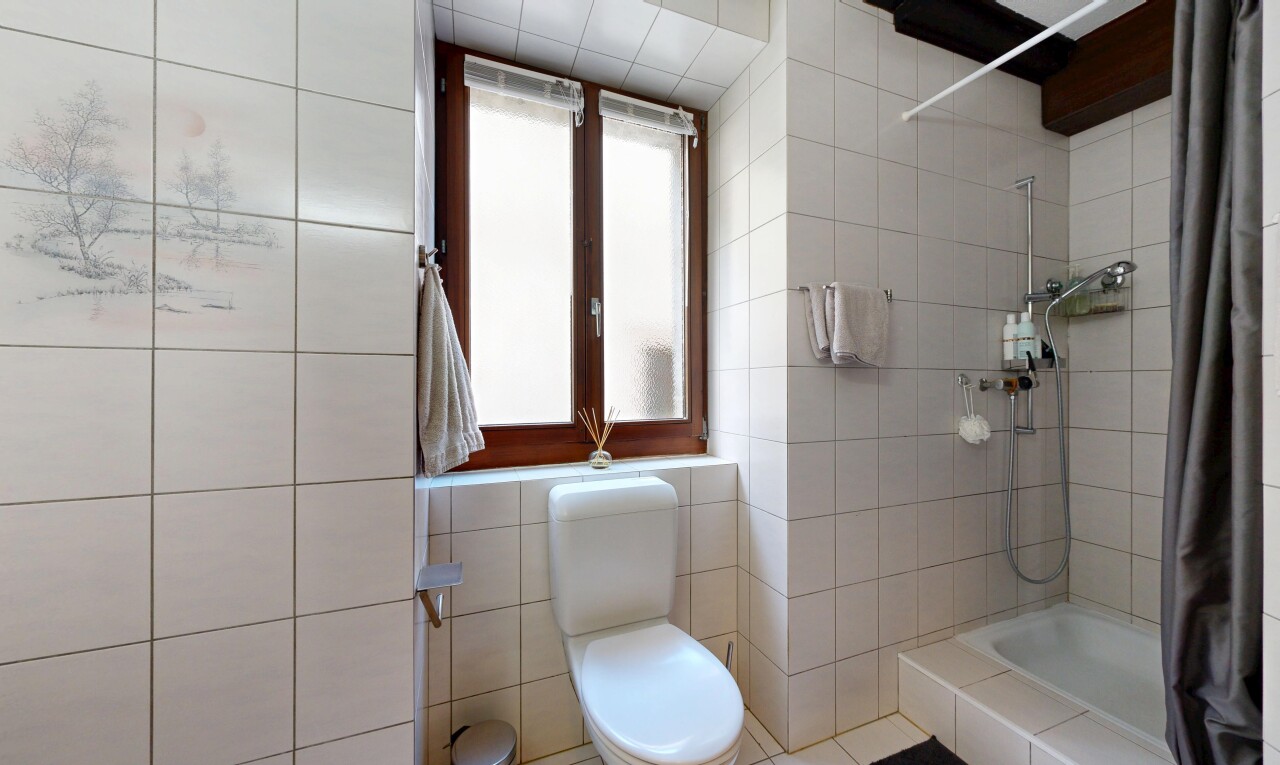 salle de bains avec douche, salle de bain complète, toilette, inside property, et mur en carrelage