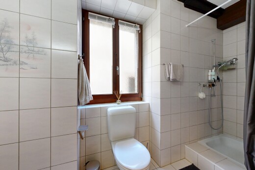 salle de bains avec douche, salle de bain complète, toilette, inside property, et mur en carrelage