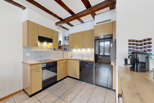 cuisine avec armoires marron clair, étagères ouvertes, four, lave-vaisselle, et backsplash