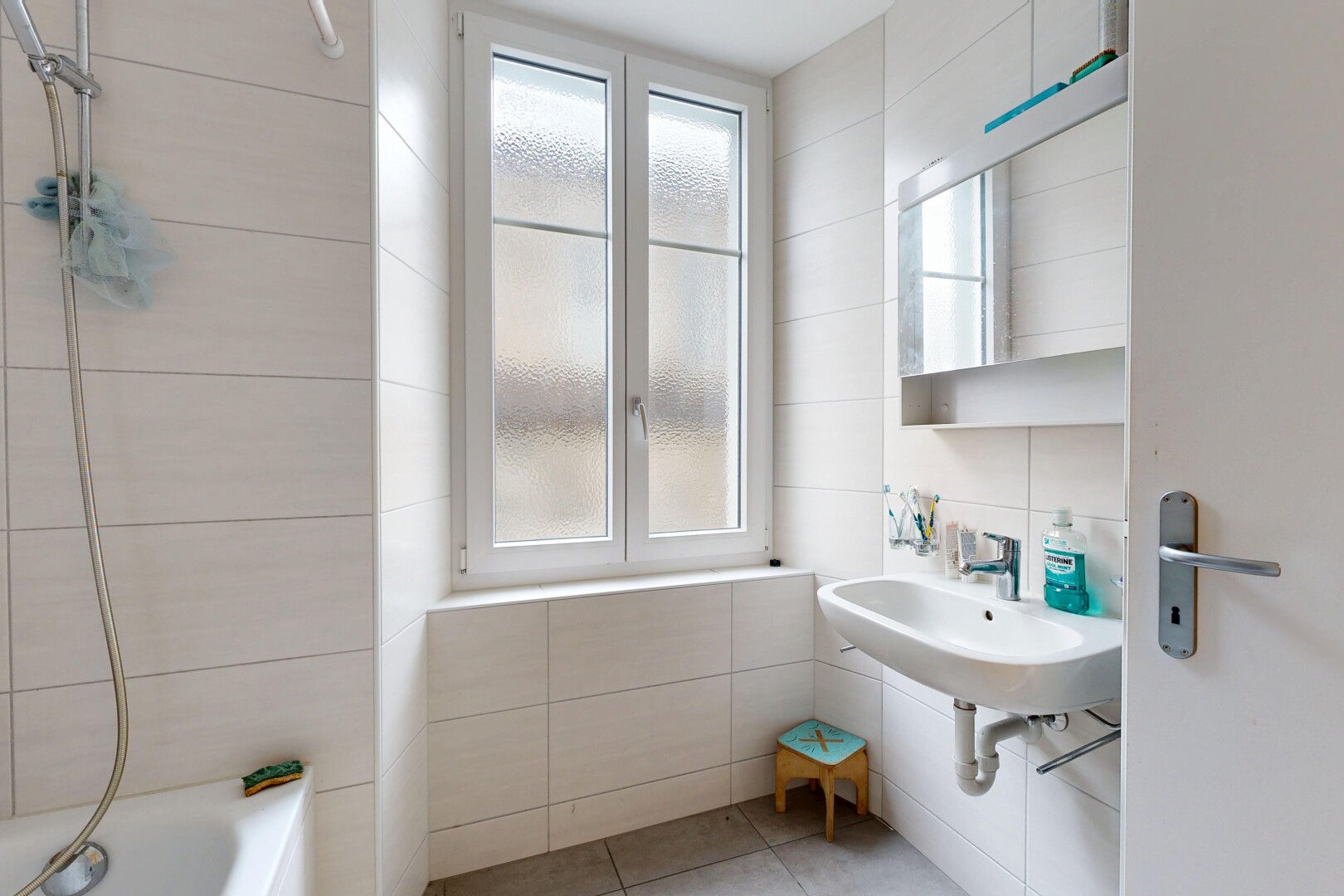 bathroom with plenty of natural light, tile walls, tile patterned floors, and shower / tub combination