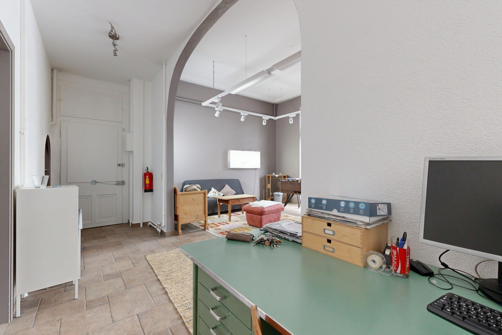 kitchen featuring arched walkways, stone finish floors, and light countertops