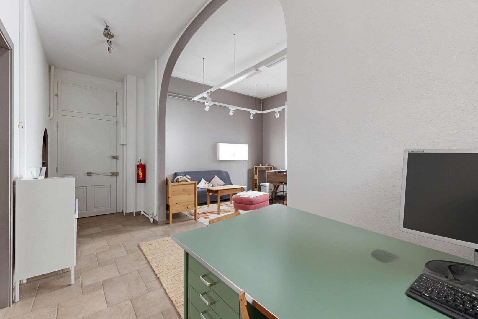 kitchen featuring arched walkways, stone finish floors, and light countertops