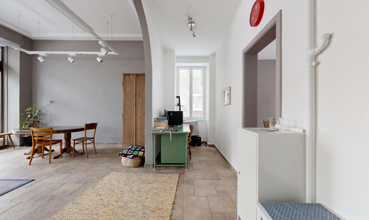 dining space with rail lighting, a desk, and arched walkways