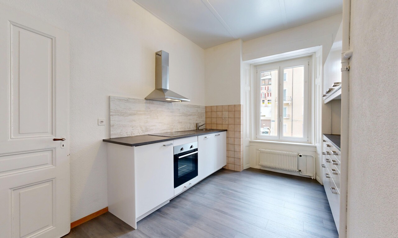 kitchen featuring wall chimney range hood, stainless steel oven, white cabinets, radiator heating unit, and light wood finished floors