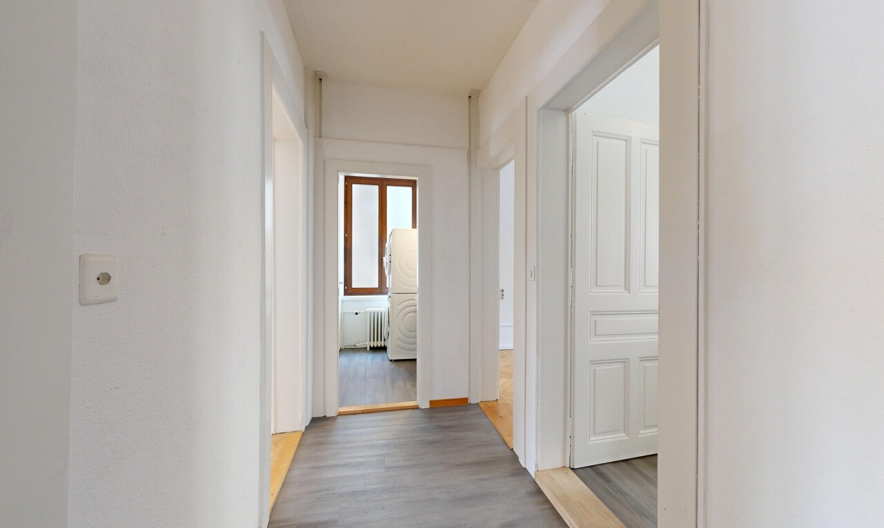 corridor with wood finished floors and radiator heating unit