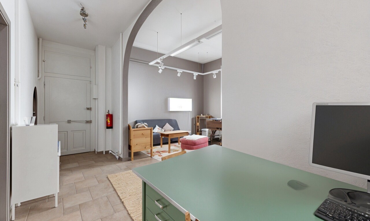 kitchen featuring arched walkways, stone finish floors, and light countertops