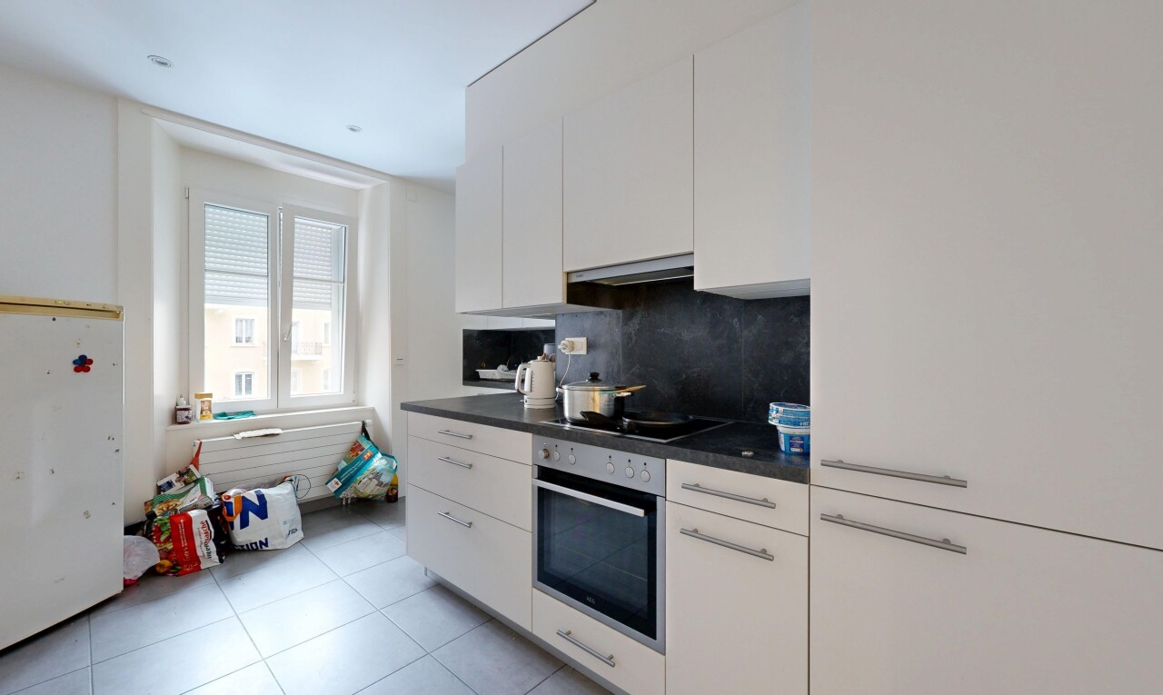 kitchen with dark countertops, white cabinetry, oven, freestanding refrigerator, and decorative backsplash