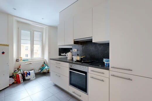 kitchen with dark countertops, white cabinetry, oven, freestanding refrigerator, and decorative backsplash