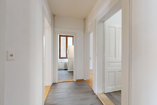 corridor with wood finished floors and radiator heating unit