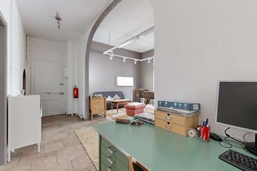 cuisine avec télévision, passages en arc, inside property, sol en finition pierre, et plans de travail