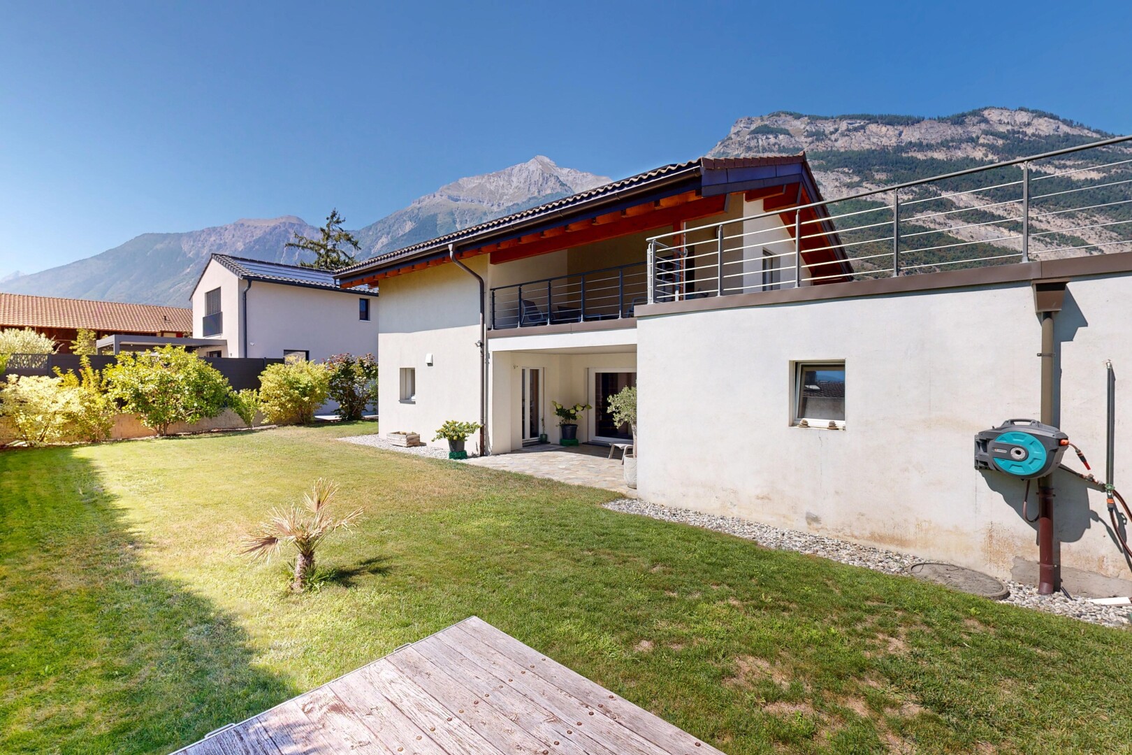 façade avec property visible, pelouse, balcon, toit en tuiles, et bardage en stuc
