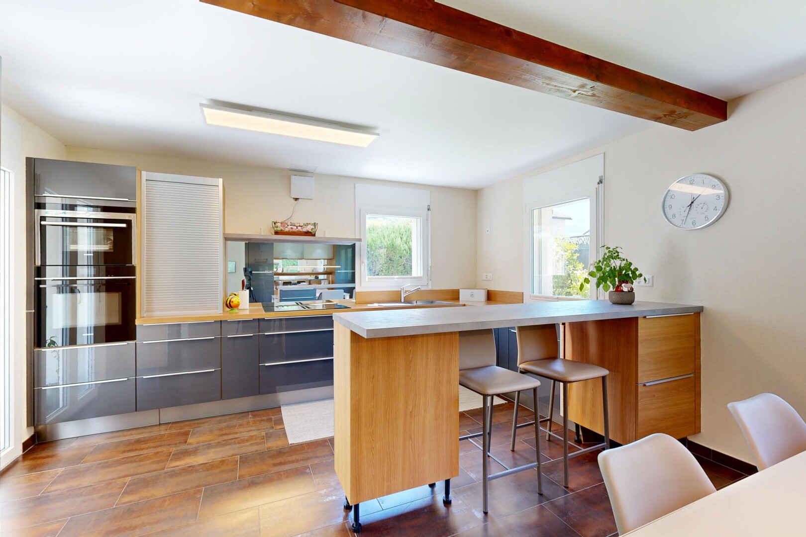 cuisine avec beamed ceiling, plafond à poutres, light countertops, plans de travail, et kitchen peninsula