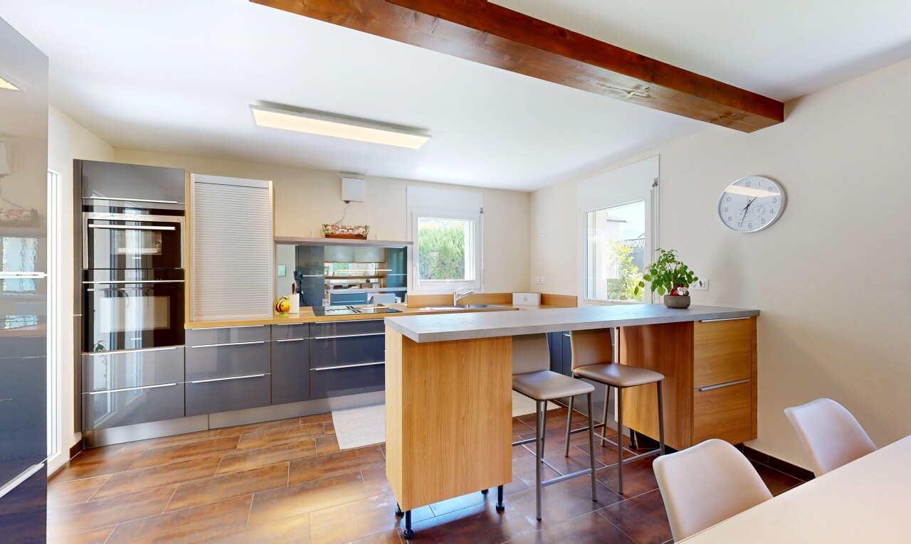 cuisine avec beamed ceiling, plafond à poutres, light countertops, plans de travail, et kitchen peninsula
