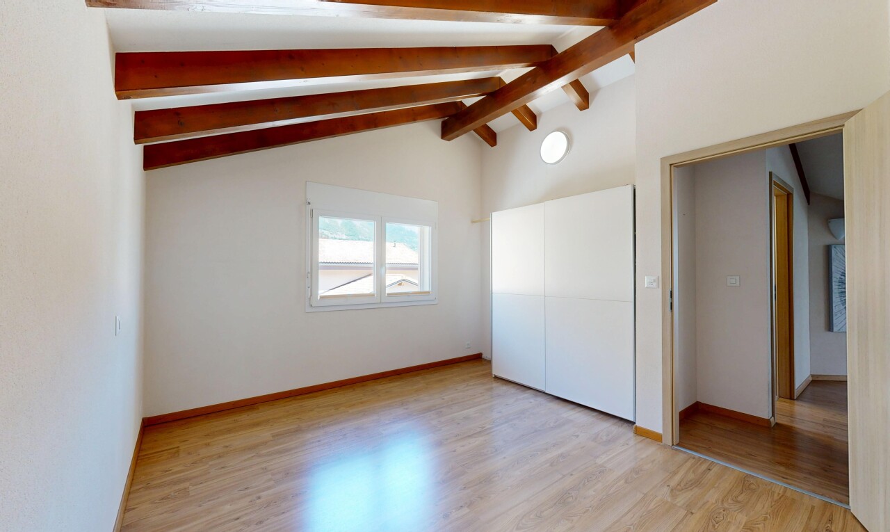 pièce vide avec plafond voûté, vaulted ceiling, plafond à poutres, beamed ceiling, et sol en finition bois