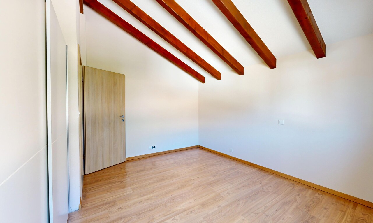 pièce vide avec beamed ceiling, plafond à poutres, vaulted ceiling, plafond voûté, et high end ceiling