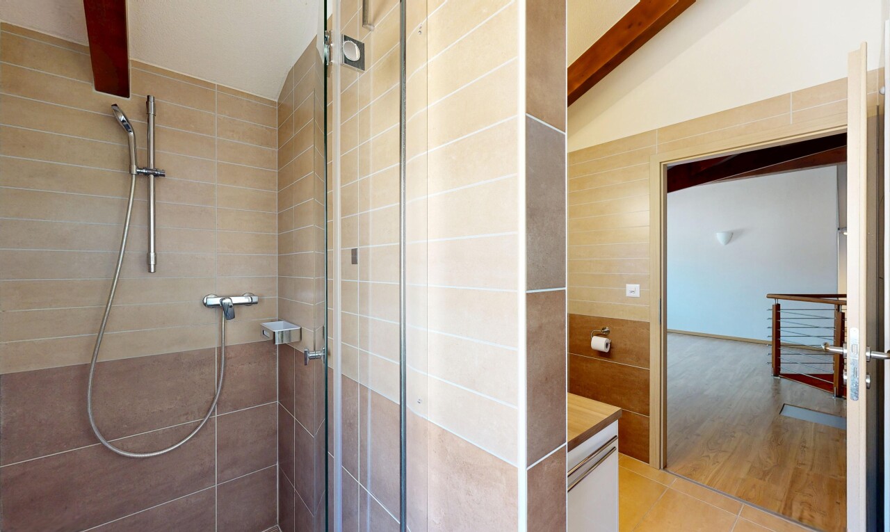 salle de bains avec douche, salle de bain complète, vaulted ceiling, plafond voûté, et tile wall