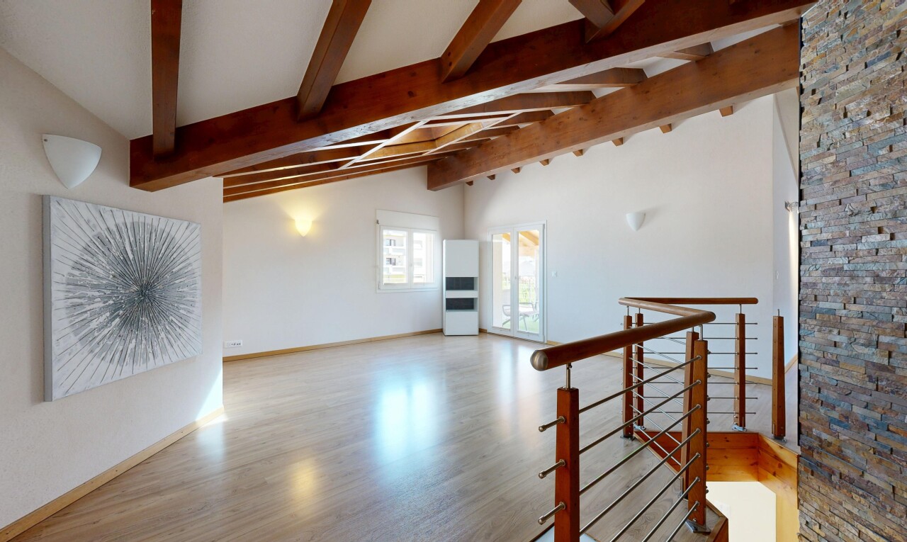 pièce vide avec vaulted ceiling, plafond voûté, beamed ceiling, plafond à poutres, et wood finish floor