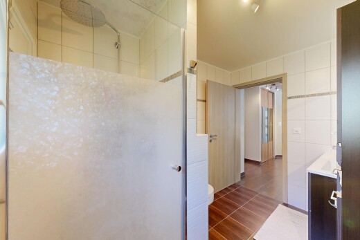 bad mit dusche, komplettes badezimmer, tile wall, dark floor, und inside property