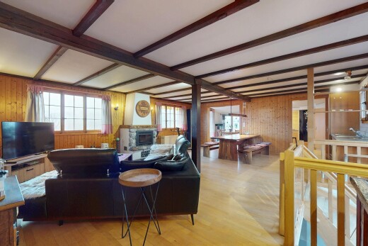 wohnzimmer mit holzwand, balkendecke, holzfußboden, natürliches licht, und fernseher