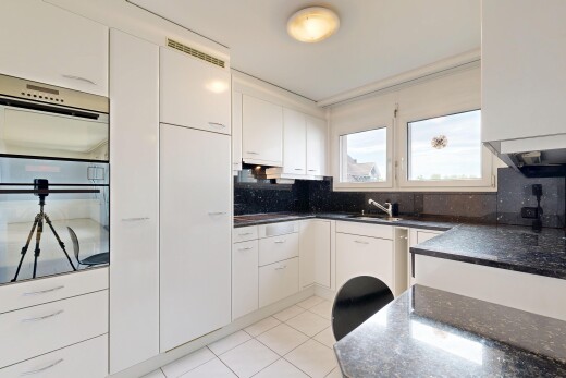 küche mit doppel backofen, dark countertops, white cabinets, weiße schränke, und light floor