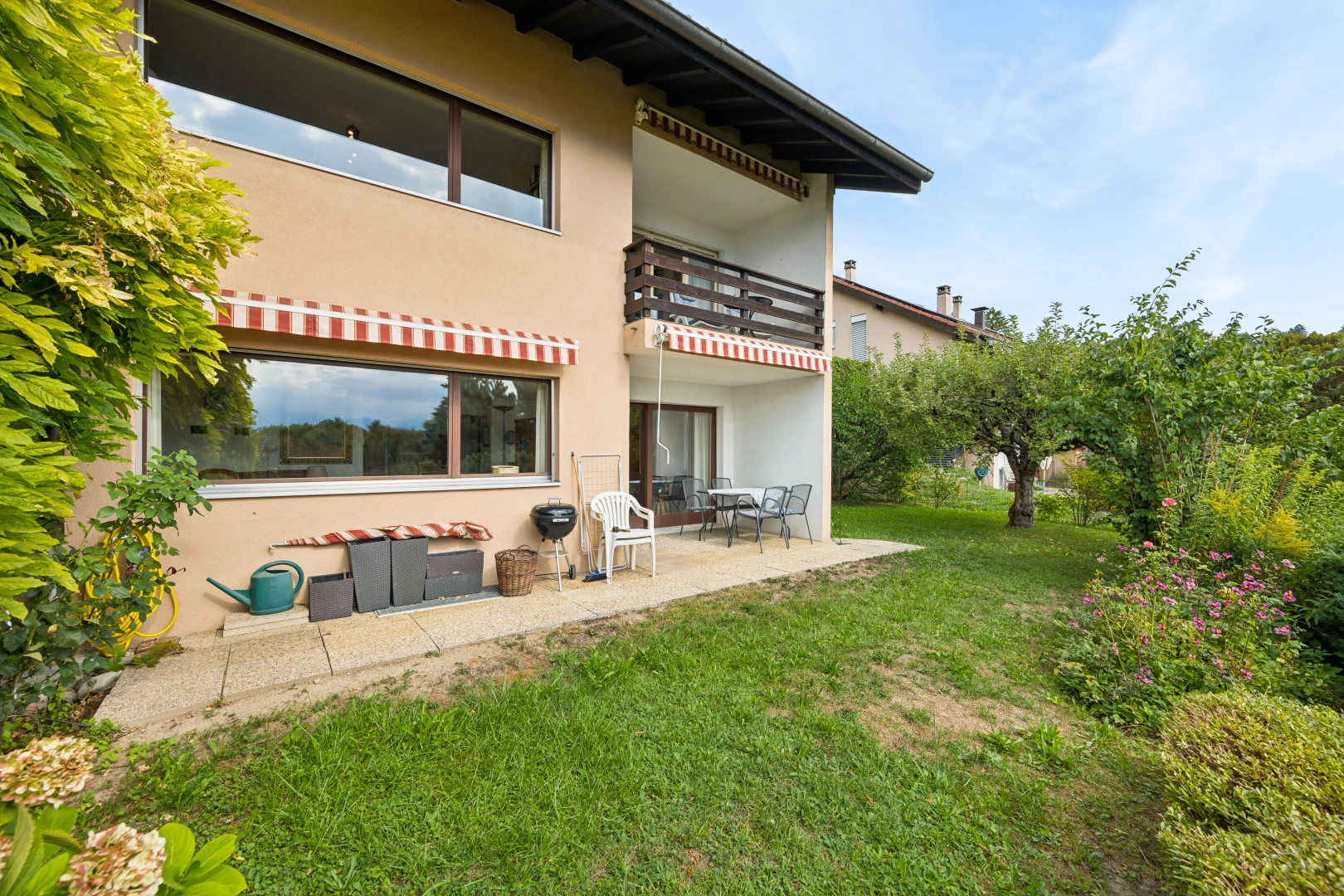 außenansicht mit markise, balkon, terrasse, stuckverkleidung, und rasen