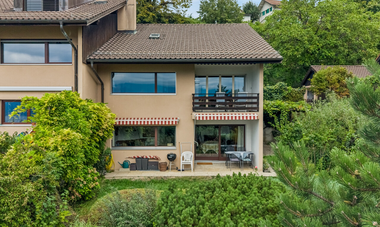 outdoor house featuring a balcony, a tiled roof, a chimney, a patio, and stucco siding