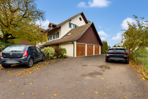façade avec property visible, bardage en stuc, day time, allée, et garage attaché