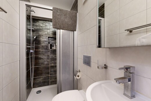salle de bains avec miroir, salle de bain complète, douche, évier, et toilette