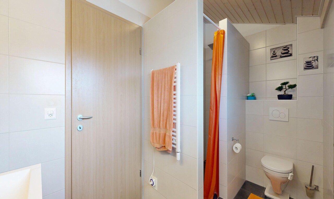 salle de bains avec chauffe-serviettes, salle de bain complète, mur en carrelage, tile wall, et inside property