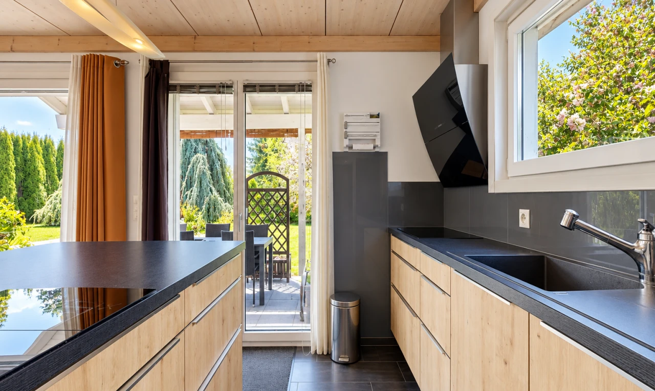cuisine avec day time, plans de travail, dark countertops, dark floor, et évier