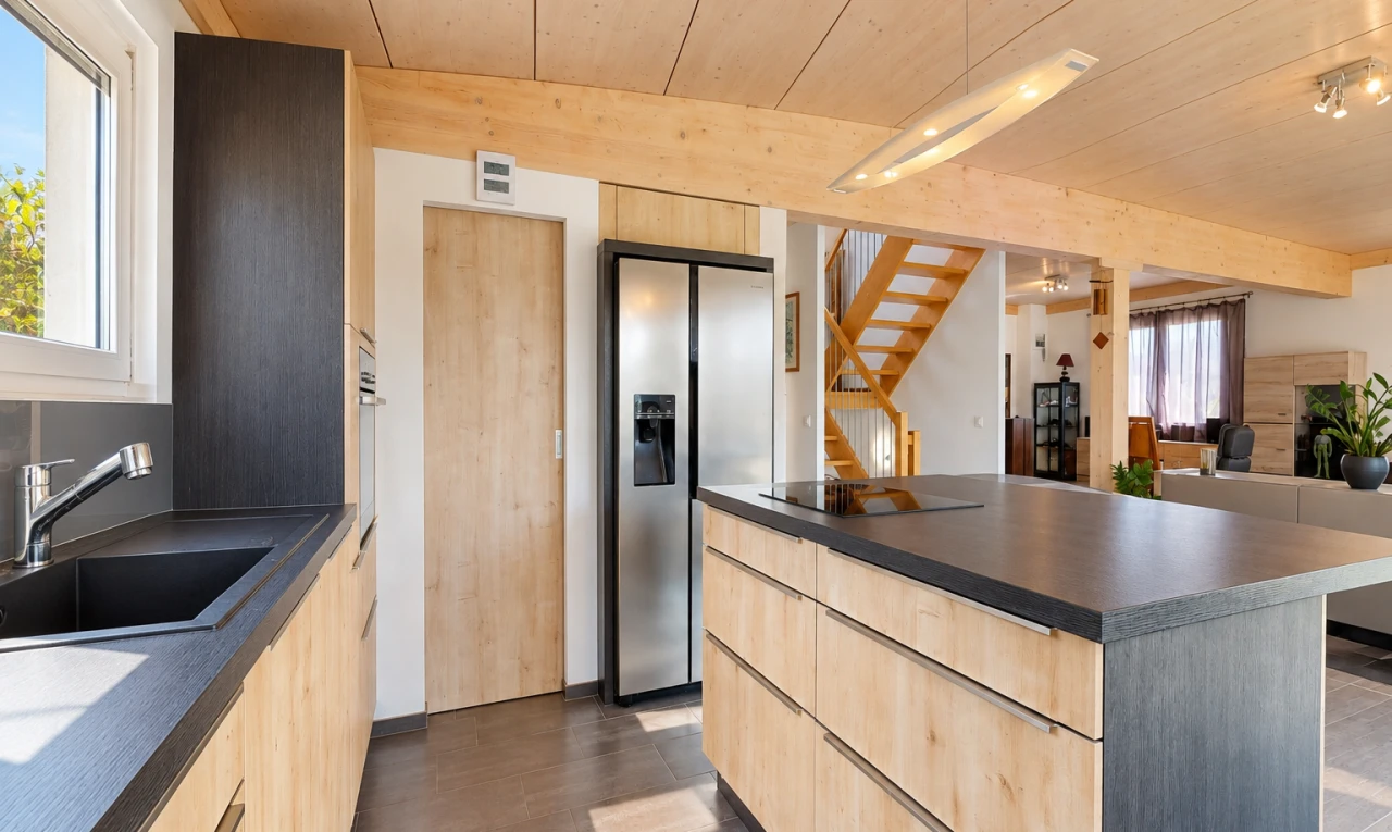 cuisine avec dark countertops, plans de travail, éclairage sur rail, light brown cabinets, et armoires marron clair