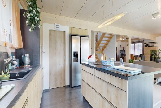 cuisine avec armoires marron clair, light brown cabinets, plans de travail, dark countertops, et inside property