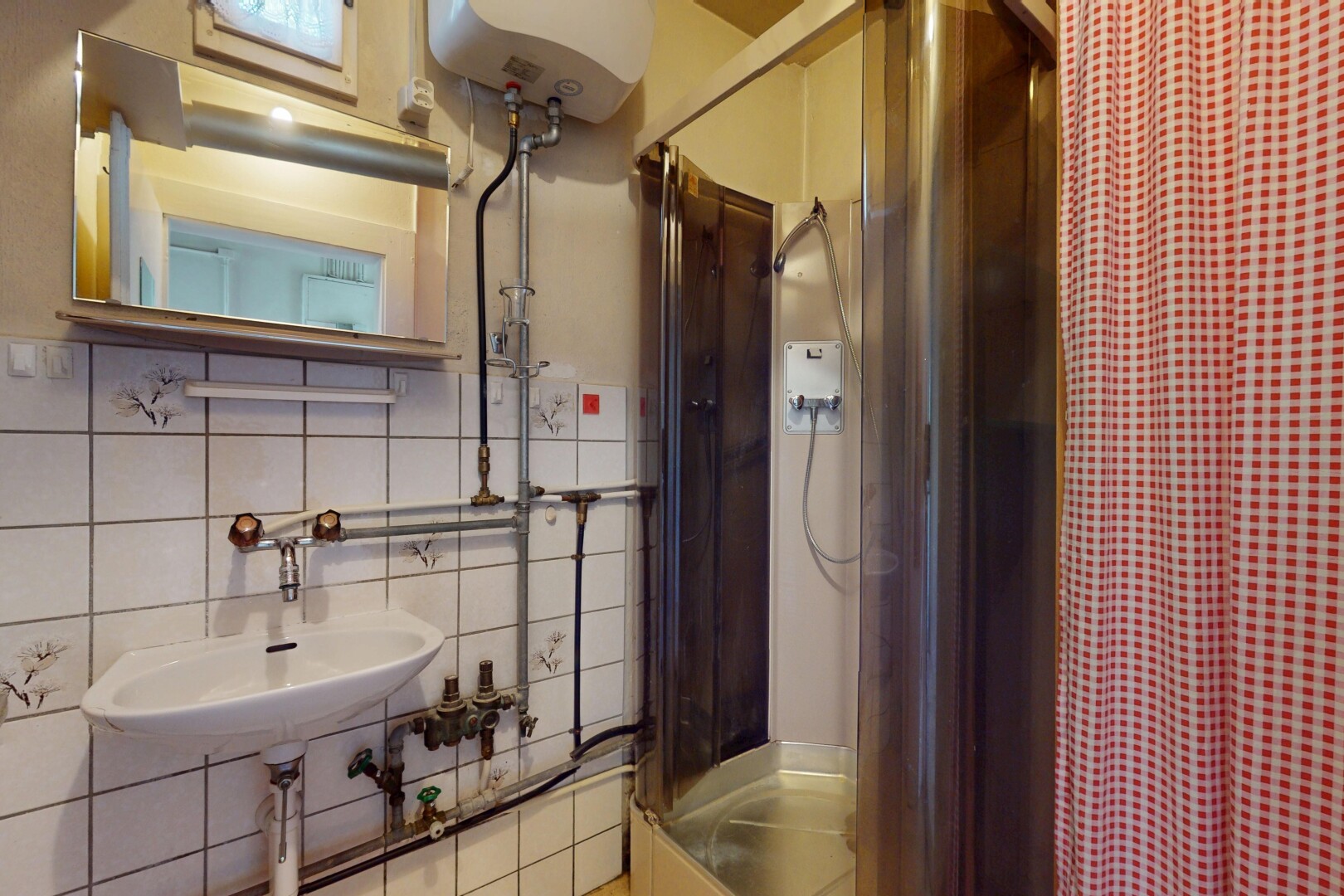 salle de bains avec inside property, miroir, chauffe-eau, dosseret, et backsplash