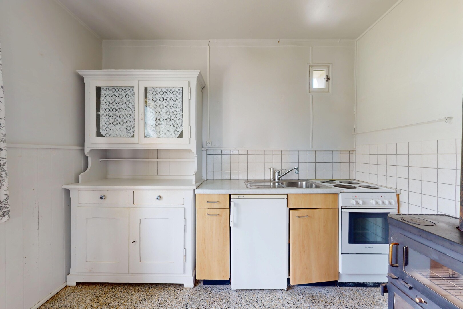 cuisine avec cuisinière, inside property, sol en agrégat, aggregate floor, et plans de travail