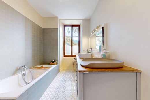 salle de bains avec salle de bain complète, miroir, bain, double vasque, et lumière naturelle