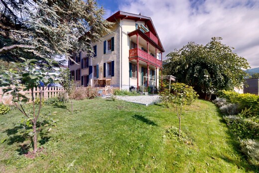 façade avec bardage en stuc, pelouse, balcon, property visible, et clôture