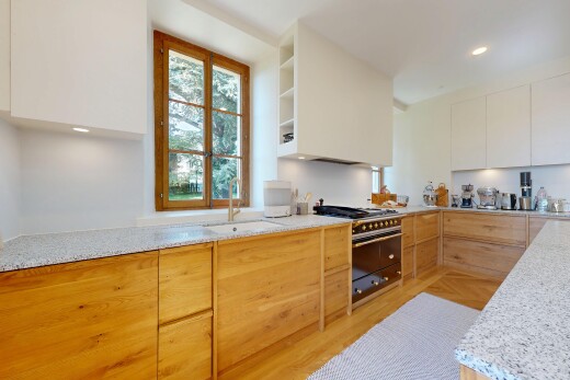 cuisine avec armoires à panneau plat, natural light, lumière naturelle, plans de travail en pierre, et cuisinière