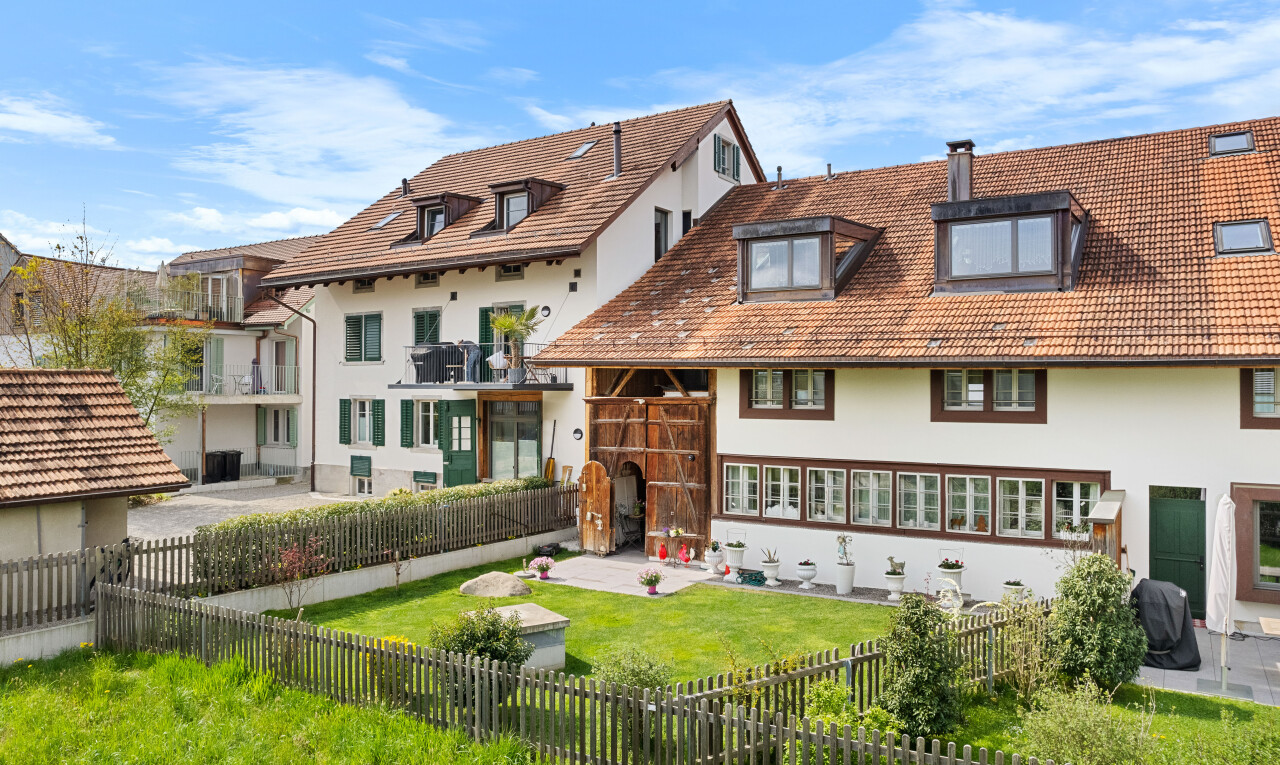 außenansicht mit zaun, stuckverkleidung, rasen, und ziegeldach