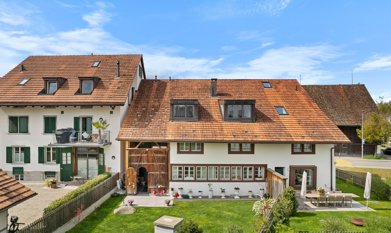 außenansicht mit terrasse, stuckverkleidung, ziegeldach, rasen, und zaun