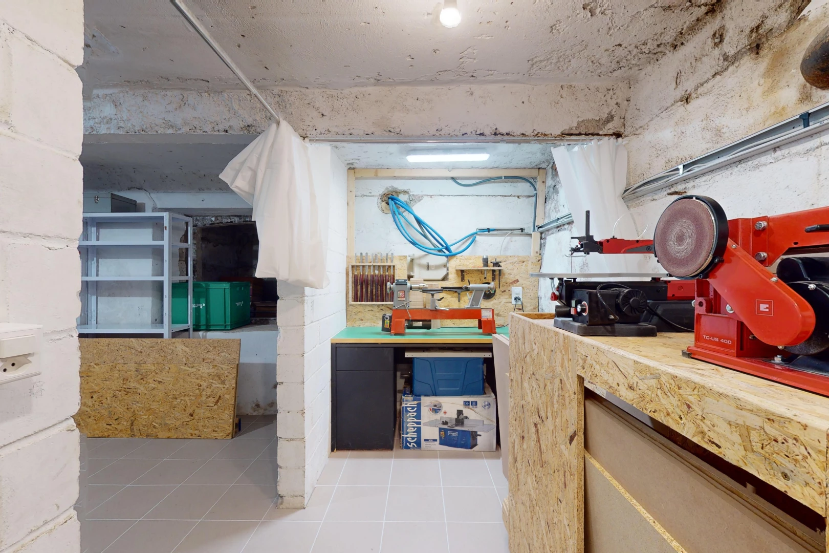 cuisine avec plan de travail, plafond en béton, et carrelage