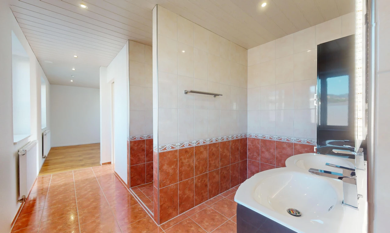 salle de bain avec mur carrelé, plancher de bois, et carrelage