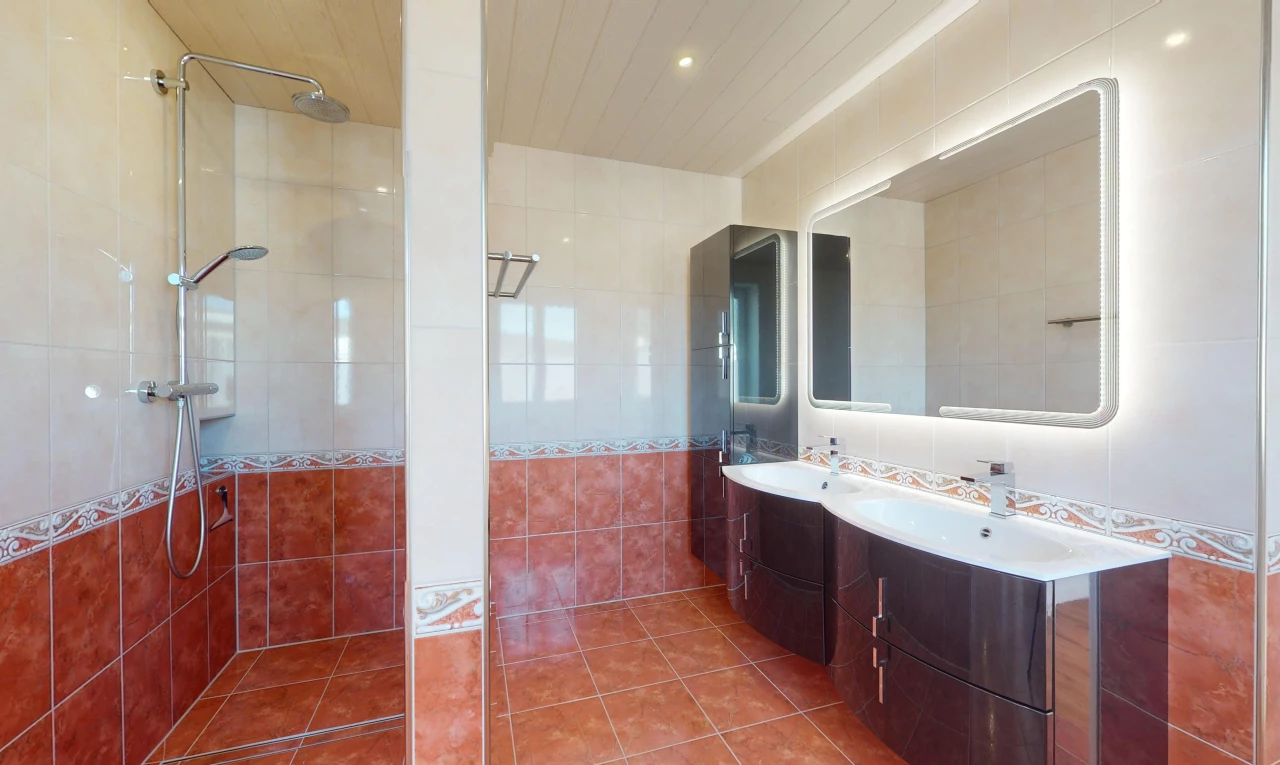 salle de bain avec douche, carrelage, mur carrelé, meuble-lavabo, et miroir