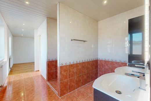salle de bain avec mur carrelé, plancher de bois, et carrelage